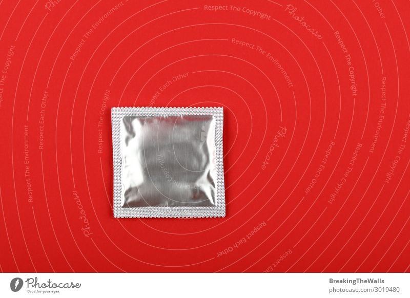 Nahaufnahme eines Kondompaketes über rotem Hintergrund Lifestyle Gesundheit Gesundheitswesen Medikament oben Sauberkeit Schutz Verantwortung Vorsicht Kontrolle