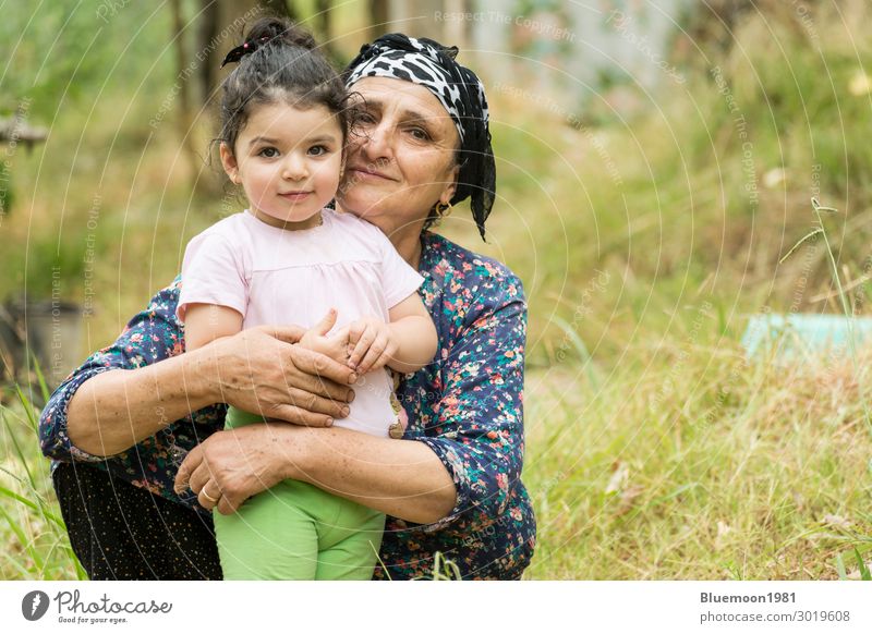Muslimische Senor-Großmutter umarmte ihr kleines Enkelkind im Garten Lifestyle Glück Gesundheit Wellness Leben Ferien & Urlaub & Reisen Kind feminin Mädchen