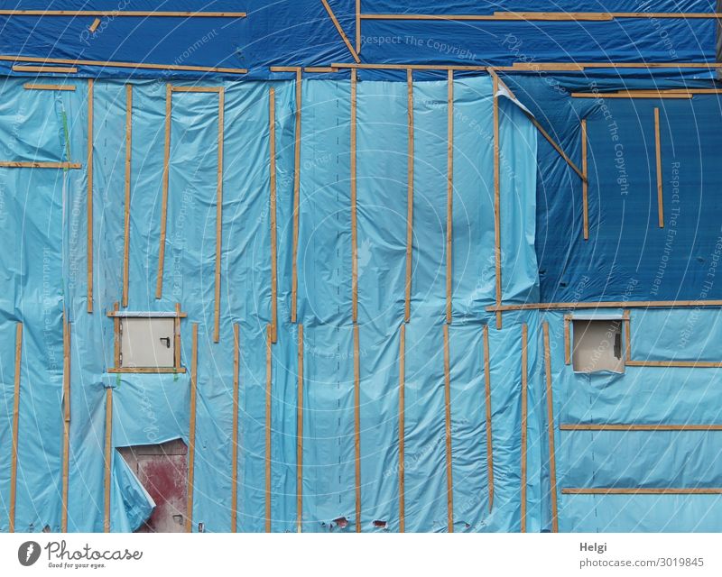 Baustelle mit einer blauen Fassadenverkleidung aus Kunsstofffolie und Holzlatten Gebäude Fenster Tür Folie Kunststoff authentisch außergewöhnlich einzigartig