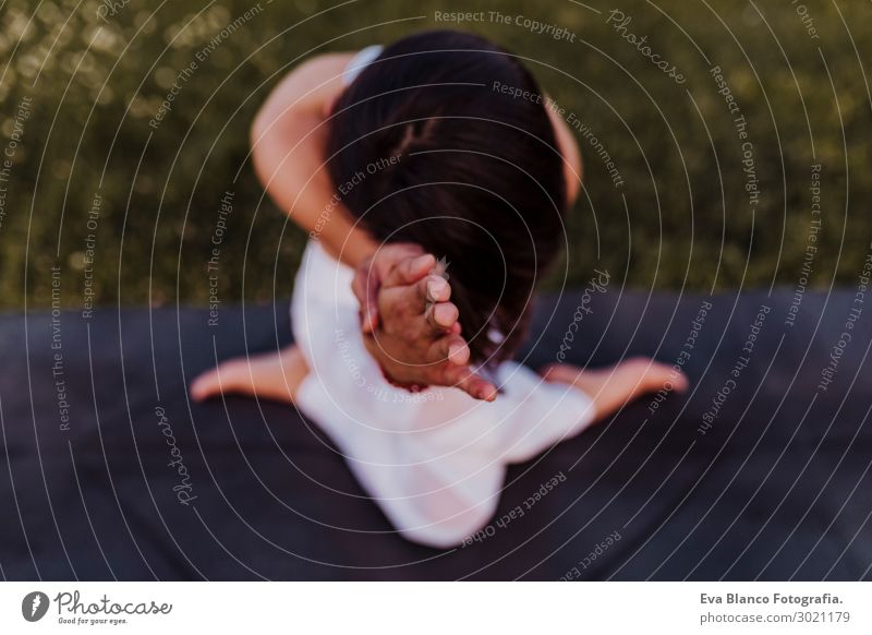 junge schöne asiatische Frau, die Yoga in einem Park bei Sonnenuntergang macht. Lifestyle Glück Körper harmonisch Erholung Meditation Sommer Musik Sport feminin