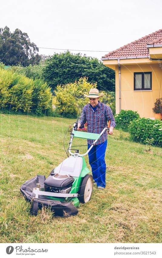 Junger Mann mäht den Rasen mit dem Rasenmäher. Sommer Haus Garten Arbeit & Erwerbstätigkeit Beruf Gartenarbeit Werkzeug Motor Technik & Technologie Mensch