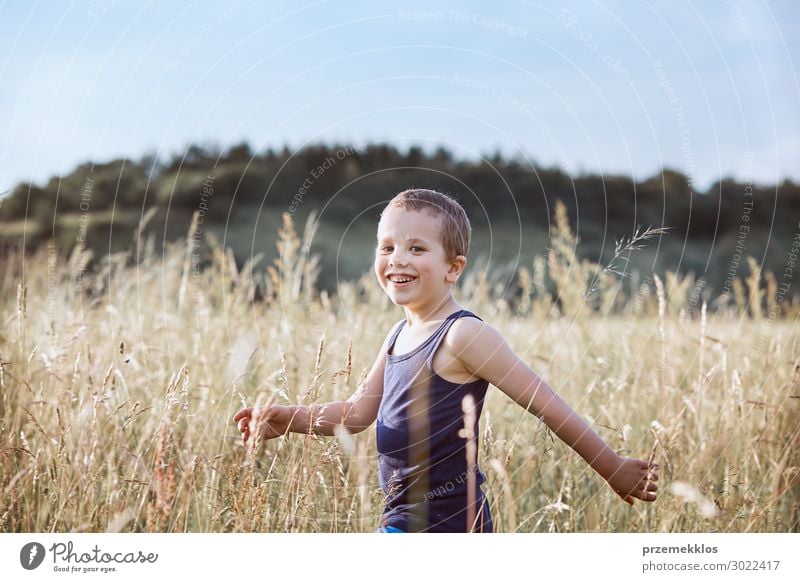 Kleiner glücklicher Junge, der durch ein hohes Gras auf dem Land läuft. Lifestyle Freude Glück Erholung Ferien & Urlaub & Reisen Sommer Sommerurlaub Kind Mensch