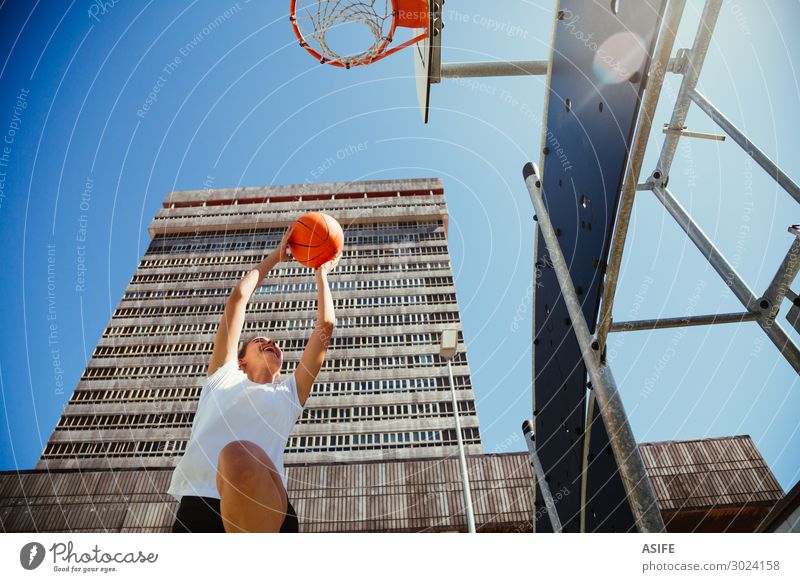 Mädchen spielt Basketball im Freien in der Stadt. Lifestyle Freude schön Spielen Sommer Sport Frau Erwachsene Jugendliche Himmel Park Hochhaus Gebäude Straße