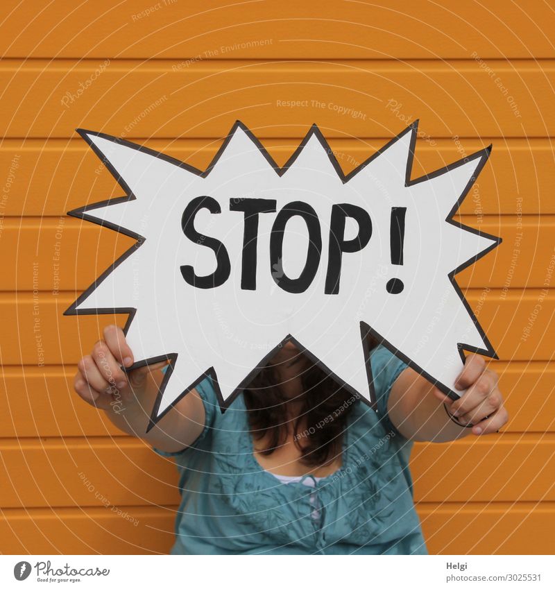 Warnschild Stop von einer Frau gehalten, vor einer orangen Wand Hand 1 Mensch 30-45 Jahre Erwachsene Fassade Bekleidung Hemd brünett langhaarig Schriftzeichen