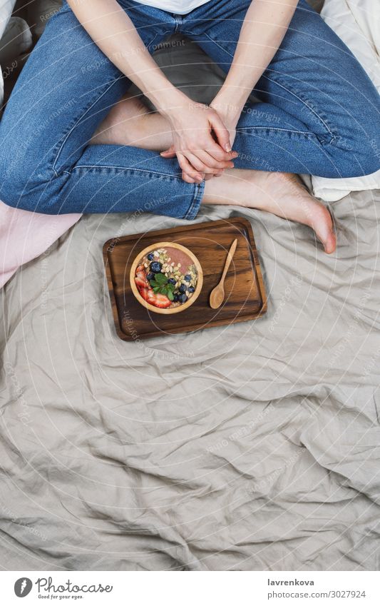 Draufsicht auf die Frau in Jeans und weißes Hemd in ihrem Bett Hintergrund neutral Bambus Bettwäsche Blaubeeren Schalen & Schüsseln Frühstück Lebensmittel