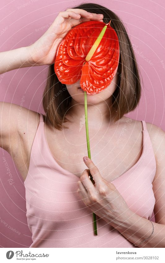 Frau in pastellrosa Kleid hält leuchtend rote Blüte Frieden Lilie Beautyfotografie Körper Pflege gesichtslos Mode Finger Blume Hand Lilien Liebe sinnlich Erotik