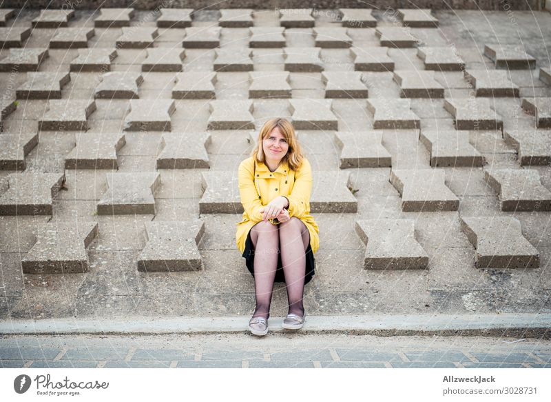 junge Frau im gelben Regenmantel sitzt auf Wellenschutzmauer Deutschland Ostsee Küste maritim Ferien & Urlaub & Reisen Urlaubsort Urlaubsfoto Erholung