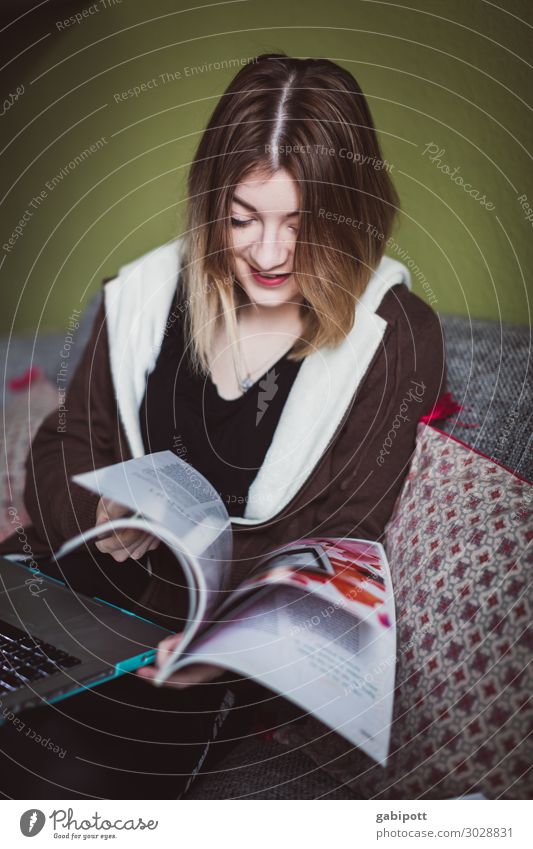 junge Frau blättert in Zeitung Stil Erholung Häusliches Leben Wohnung Wohnzimmer Mensch feminin Junge Frau Jugendliche 1 18-30 Jahre Erwachsene lesen sitzen