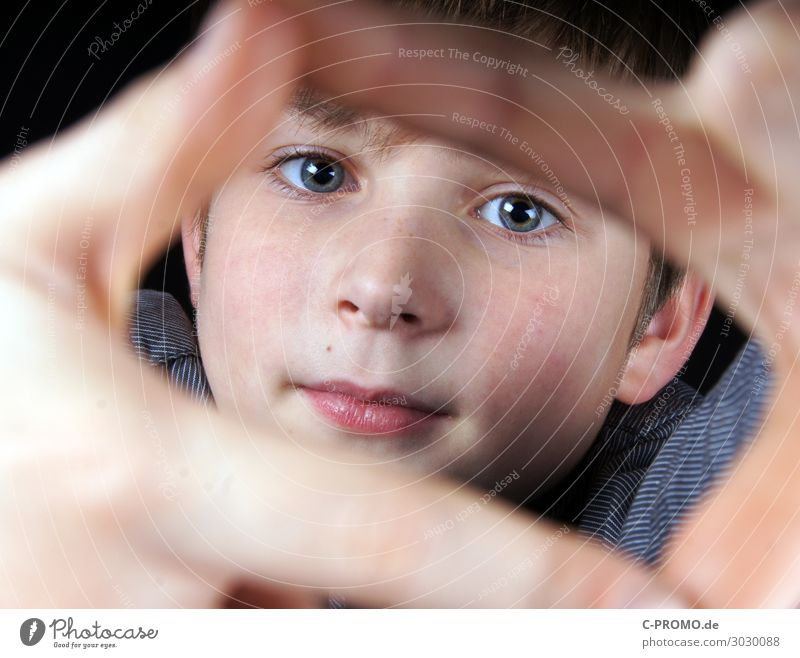 Junge schaut durch Rahmen seiner Finger Mensch maskulin Gesicht Auge 1 3-8 Jahre Kind Kindheit 8-13 Jahre Neugier Interesse Lächeln Farbfoto
