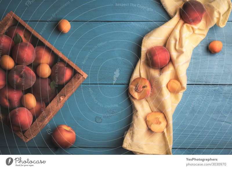 Frische Pfirsiche und Aprikosen in Holzkiste Frucht Tisch Küche frisch lecker natürlich saftig gelb obere Ansicht Ackerbau Biografie blauer Tisch Kiste