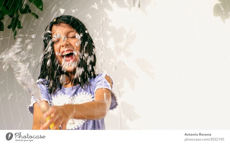 lächelndes Mädchen mit Schlauchbewässerung am Sommertag Lifestyle Freude Kind Mensch Pflanze Baum Lächeln Coolness frisch nass 6s sechsjährig Bewässerung