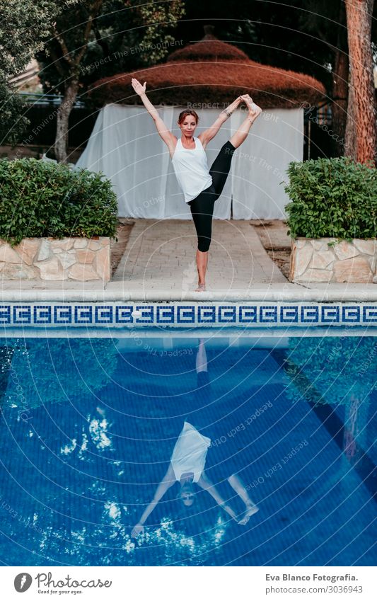 Frau, die Yoga am Swimmingpool macht. Yoga und Achtsamkeit Lifestyle schön Körper Erholung ruhig Meditation Spa Schwimmbad Freizeit & Hobby
