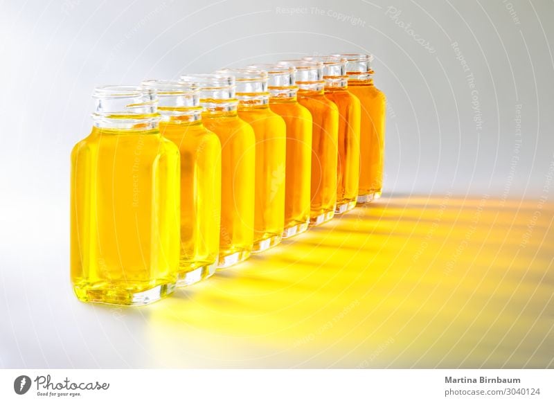 Flaschen mit gelben Flüssigkeiten in verschiedenen Gelbtönen Gemüse Bier frisch nass braun weiß vereinzelt Erdöl Hintergrund Palette Schirme Wasser liquide