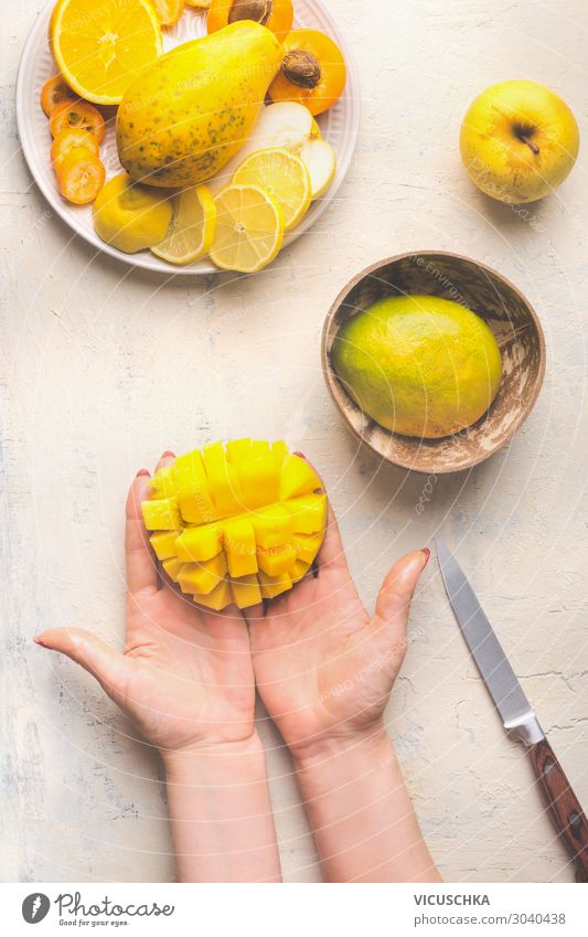 Hände halten halbe gewürfelte Mango Lebensmittel Frucht Ernährung Bioprodukte Vegetarische Ernährung Diät Geschirr Design Gesunde Ernährung Tisch Frau