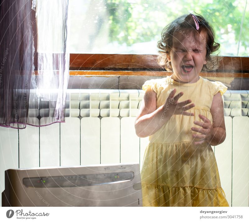 Kleines Mädchen in einem staubigen Raum. Luftreiniger und hustendes Kind. Gesundheitswesen Kindheit Erde frisch Sauberkeit Staubwischen Alergie Allergen