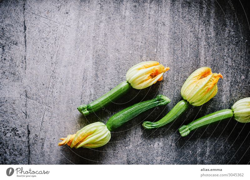 Zucchinis mit Blüten auf Steinplatte Lebensmittel Gemüse Ernährung Mittagessen Abendessen Bioprodukte Vegetarische Ernährung Diät gelb grau grün orange schwarz