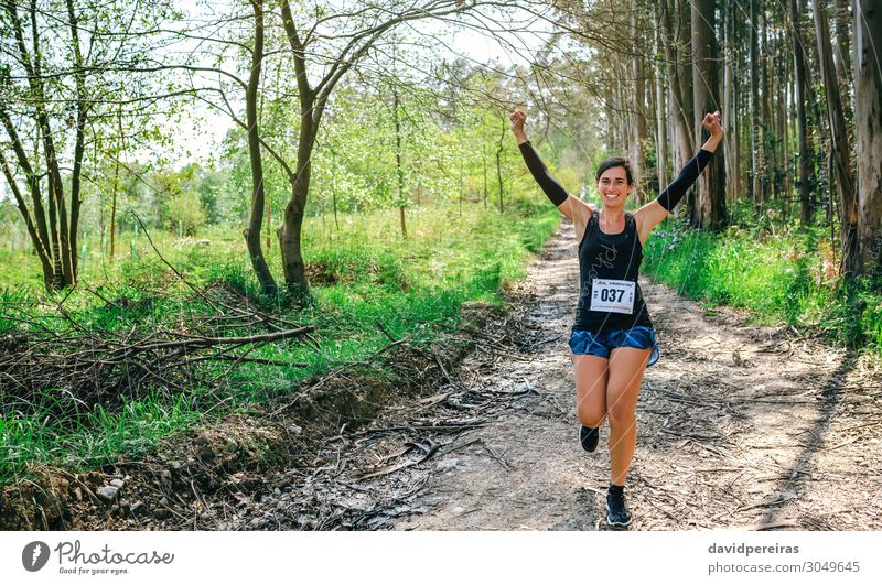 Junge Frau gewinnt Trail Race Lifestyle Glück Feste & Feiern Sport Erfolg Mensch Erwachsene Natur Baum Wald Wege & Pfade Turnschuh Fitness Lächeln