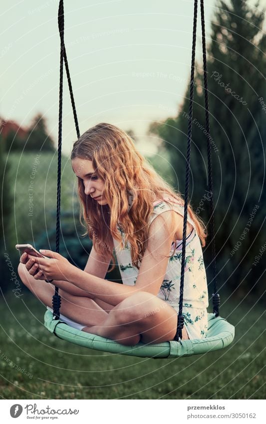 Junge Frau nutzt Handy-Smartphone lesen Sommer Sommerurlaub Garten Telefon Technik & Technologie Internet Jugendliche Erwachsene 1 Mensch 13-18 Jahre sitzen