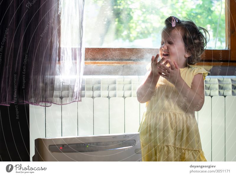 Kleines Mädchen in einem staubigen Raum. Luftreiniger und hustendes Kind. Gesundheitswesen Kindheit Erde frisch Sauberkeit Staubwischen Alergie Allergen