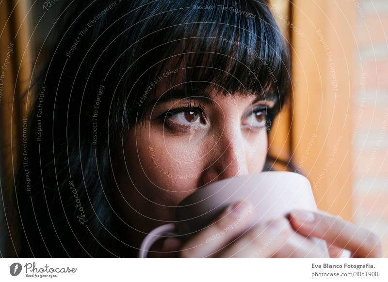 junge Frau zu Hause am Fenster bei einem Kaffee trinken Tee Lifestyle schön Leben Erholung Freizeit & Hobby lesen Ferien & Urlaub & Reisen Wohnung Möbel