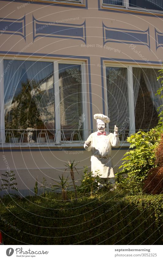 Der Koch lädt ein Gastronomie Haus Fenster Kitsch Krimskrams retro genießen Gedeckte Farben Außenaufnahme Zentralperspektive