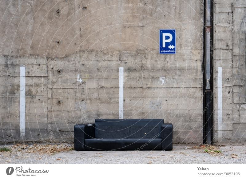 Ausgeparkt Feierabend Häusliches Leben alt Stadt grau schwarz Verfall Sofa Sperrmüll verschwenden Parkplatz Betonwand Farbfoto Außenaufnahme