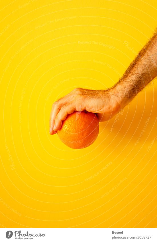 orange in der Hand an der gelben Wand II Frucht Lifestyle Design Mensch Mann Erwachsene Arme Finger Natur genießen frisch Farbe Menschen Grafik u. Illustration