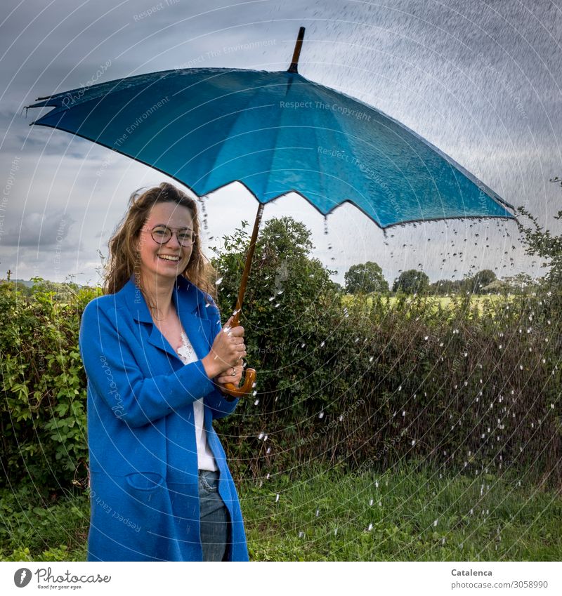 Regenwetter, Wassertropfen prallen ab am Regenschirm der jungen Frau im blauen Regenmantel Junge Frau Jugendliche 1 Mensch 18-30 Jahre Erwachsene Natur