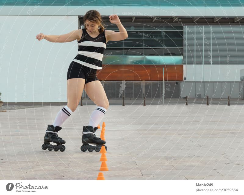 Frau, die auf der Straße Schlittschuh läuft und Kegel herstellt. Lifestyle Stil Freude Glück schön Freizeit & Hobby Freiheit Sport feminin Erwachsene Körper
