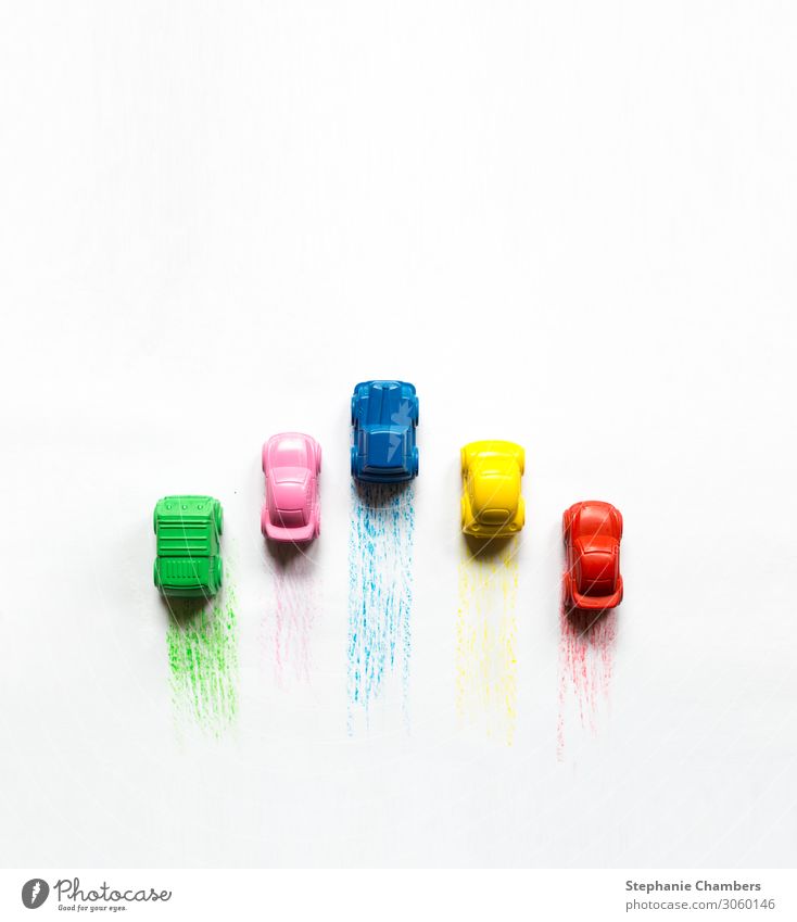 Fünffarbige Kreidewagen mit Farbspuren. PKW mehrfarbig KFZ bunt Flachlegung Zoomeffekt Farbstift Farbfoto
