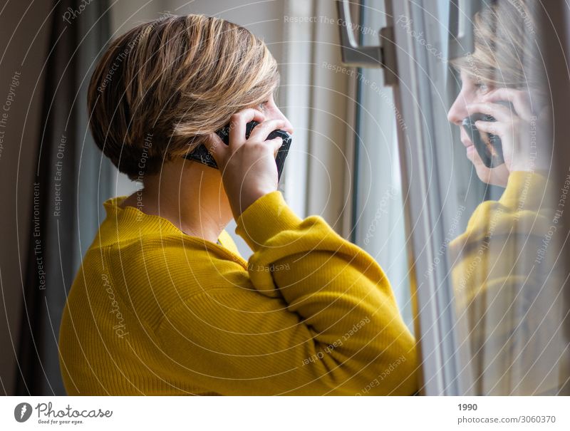 Mädchen am Telefon, das aus dem Fenster schaut. Lifestyle Handy Mensch feminin Junge Frau Jugendliche 1 18-30 Jahre Erwachsene Pullover Strickpullover blond