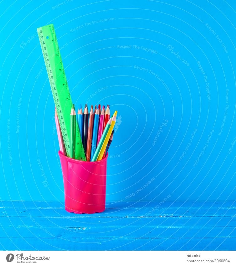 blaues Briefpapierglas mit mehrfarbigen Holzstiften Tisch Schule Klassenraum Studium Arbeitsplatz Büro Schreibstift zeichnen Farbe Idee Kreativität