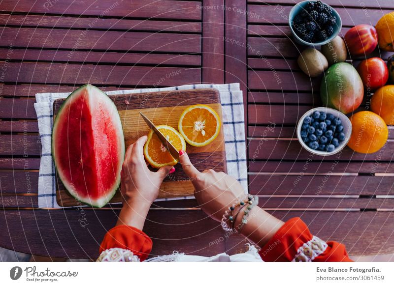 junge Frau, die ein gesundes Rezept aus verschiedenen Früchten, Wassermelone, Orange und Brombeere zubereitet. Verwendung eines Mixers. Hausgemacht, drinnen, gesunde Lebensweise
