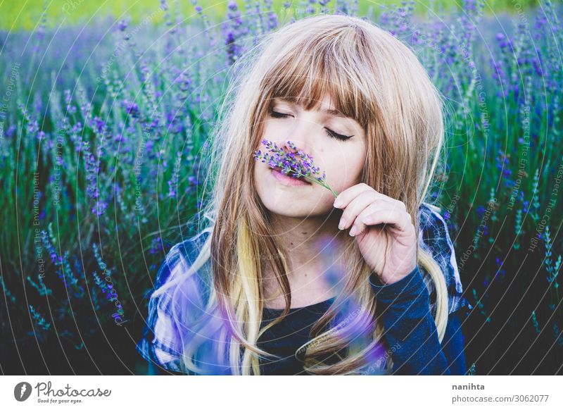 Junge Frau genießt den Tag in einem Lavendelfeld. Kräuter & Gewürze Lifestyle schön Gesicht Kosmetik Alternativmedizin Medikament Leben Erholung Mensch feminin