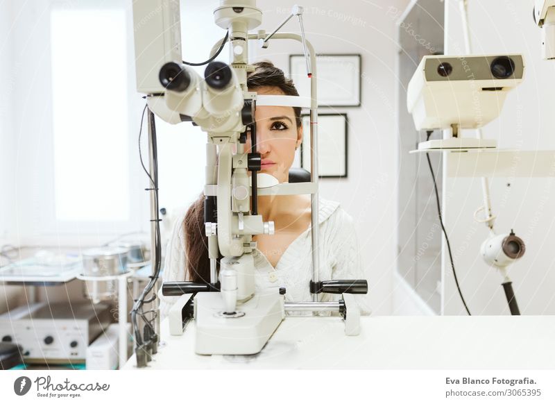 junge Frau beim Augenarzt sitzend Gesicht Behandlung Krankheit Medikament Prüfung & Examen Arbeit & Erwerbstätigkeit Beruf Arzt Büro feminin Junge Frau