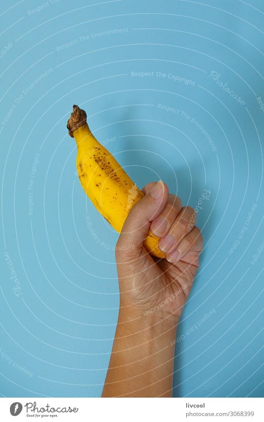 Banane auf blauer Wand II Lebensmittel Gemüse Frucht Ernährung Lifestyle Design Mensch Frau Erwachsene Arme Hand Finger Natur genießen frisch Gesundheit lecker