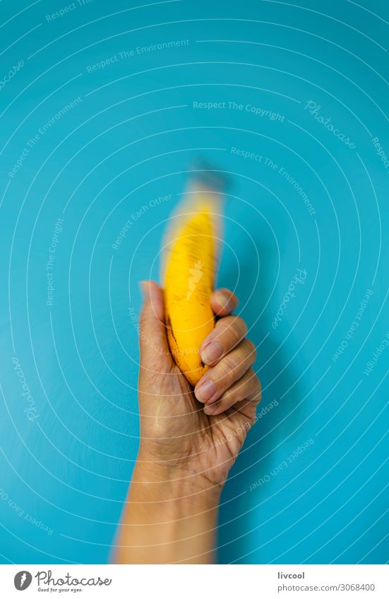 Banane auf blauer Wand Gemüse Frucht Ernährung Bioprodukte Vegetarische Ernährung Diät Lifestyle Design Mensch Frau Erwachsene Arme Hand Finger Natur Essen