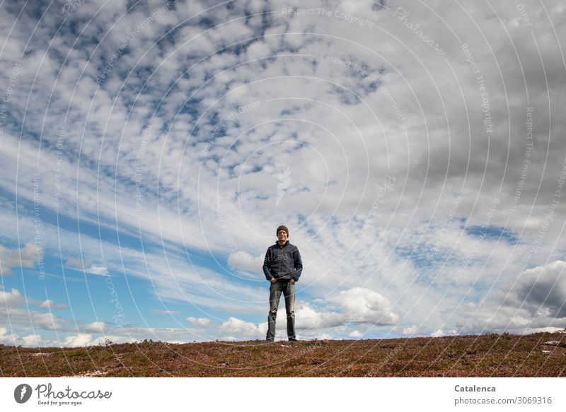 Mann steht auf der Hügelkuppe, der weite mit Wolken verzierte Himmel über ihn Natur Landschaft Person männlich stehen beobachten rote Mütze Horizont Wetter
