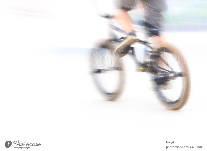 rasanter Radfahrer unterwegs im Sportpark mit Bewegungsunschärfe Fahrradfahren Sportstätten Mensch Jugendliche Beine 1 13-18 Jahre Hose Turnschuh authentisch