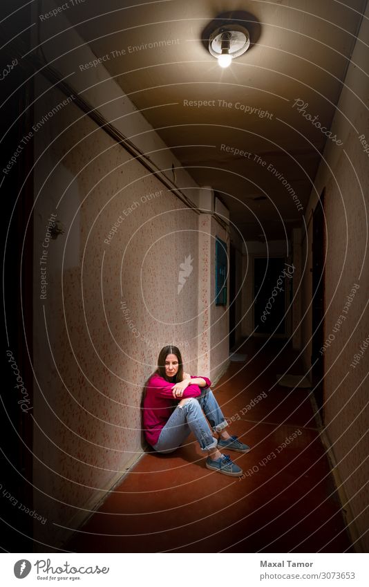 Traurige und verzweifelte Frau sitzt in einem dunklen Korridor. Erwachsene sitzen Traurigkeit dunkel Gefühle Sorge Trauer Einsamkeit Fürsorge Verlassenwerden
