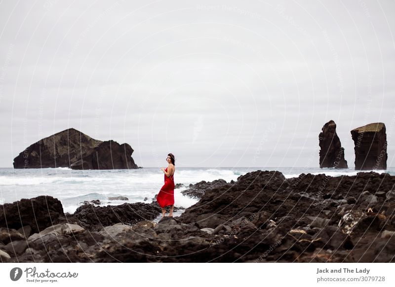 Rote Frau feminin Erwachsene 1 Mensch Landschaft Erde Wasser Gewitterwolken Unwetter Felsen Wellen Mosteiros Portugal Europa Dorf Sehenswürdigkeit Kleid Stein