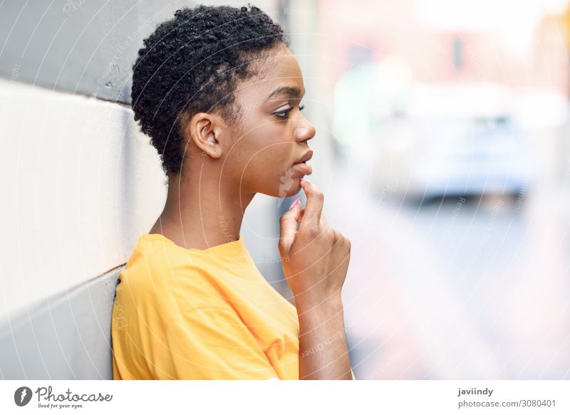 Nachdenkliche schwarze Frau mit traurigem Gesichtsausdruck auf Stadtmauer Lifestyle Stil schön Haare & Frisuren Mensch feminin Junge Frau Jugendliche Erwachsene