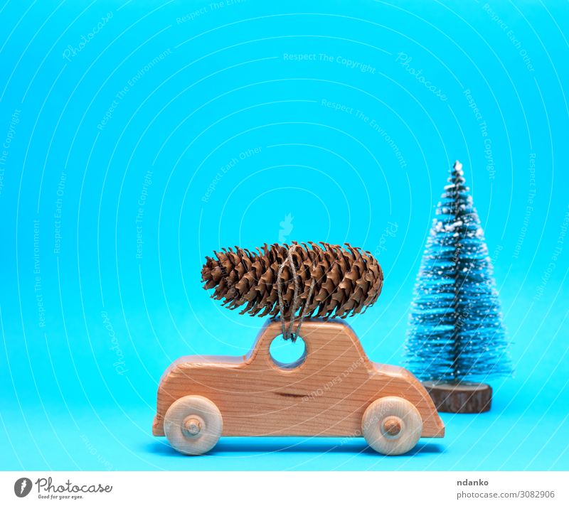 Holzspielzeugauto trägt oben einen Kiefernzapfen. Winter Dekoration & Verzierung Feste & Feiern Weihnachten & Advent Silvester u. Neujahr Baum Verkehr PKW