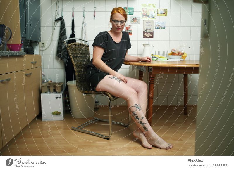 Portrait einer jungen, tätowierten Frau, die barfuß in ihrer Küche sitzt Lebensmittel Stil schön harmonisch Wohnung Junge Frau Jugendliche Beine 18-30 Jahre