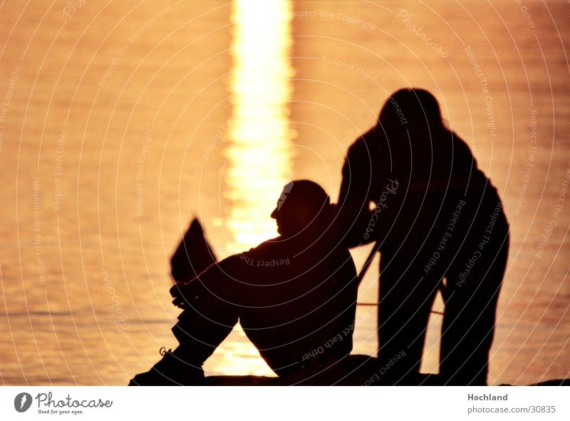 Schnürsenkel am Abend Schuhbänder Sonnenuntergang Fotograf Abenddämmerung Mann Frau Gegenlicht Wasser Paar sitzen