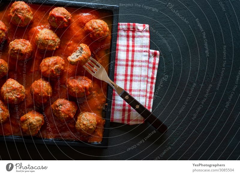 Fleischbällchen in Tomatensauce auf schwarzem Tablett. Oben Ansicht der Fleischplatte Essen Mittagessen Abendessen Teller Gabel Tisch Restaurant dunkel lecker