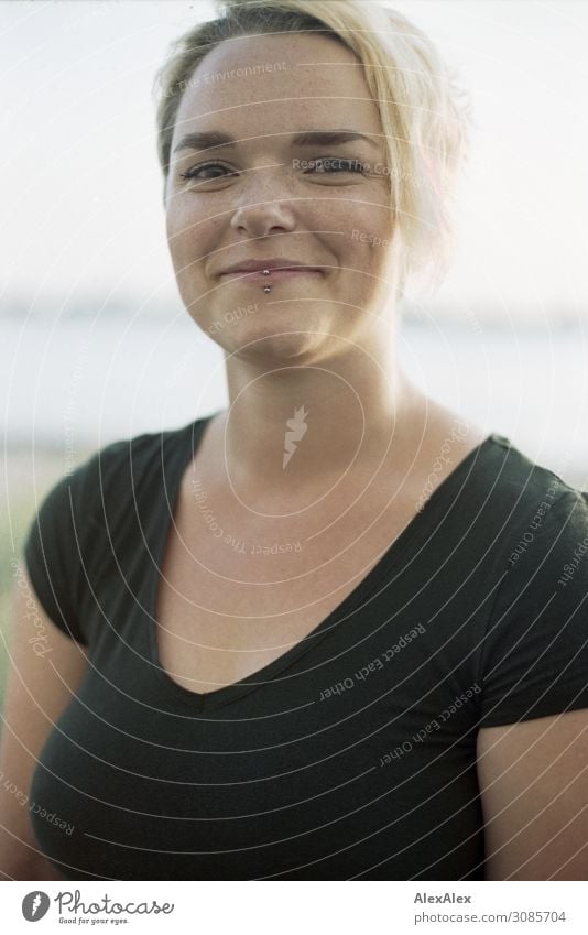 Portrait einer lächelnden, jungen Frau in schwarzem Top vor der Elbe Lifestyle Freude schön Leben Wohlgefühl Junge Frau Jugendliche Grübchen 18-30 Jahre