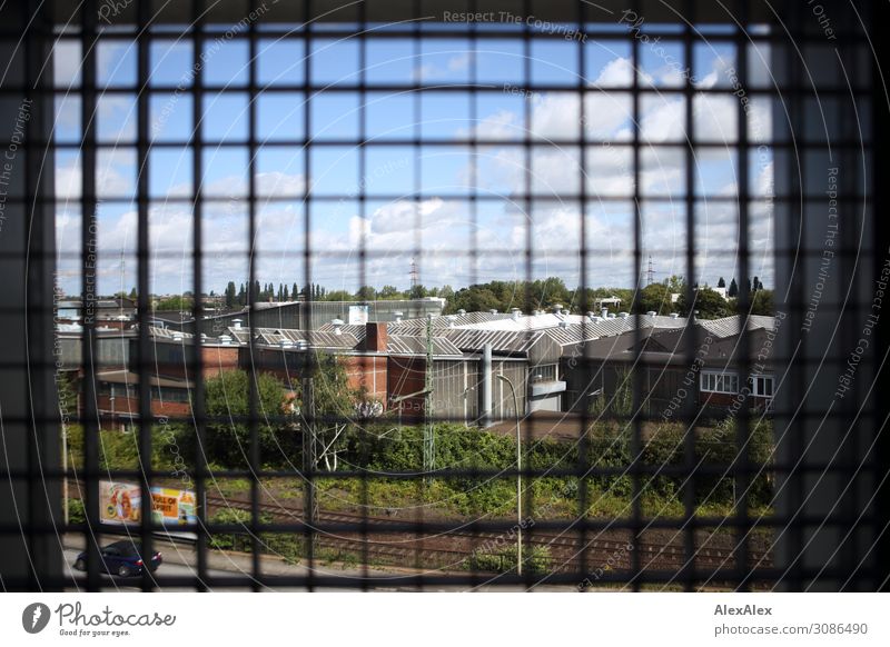 Ausblick durch Gitterfenster auf einen Fabrik - Rasterfahndung Industrie Gitterrost Eisenbahn Gleise Fabrikhalle Fensterblick Landschaft Himmel Sommer