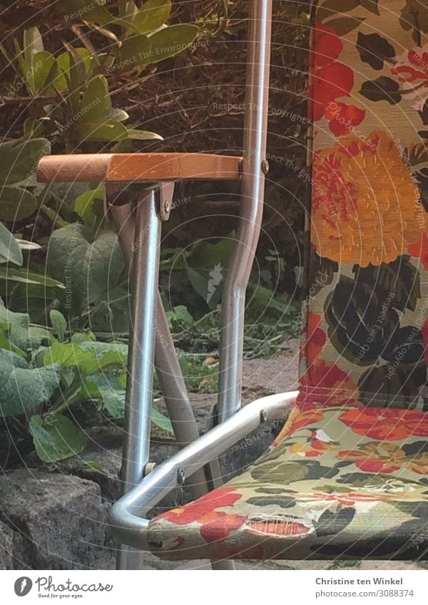 alter stoffbespannter Campingstuhl mit Blumenmuster Stuhl authentisch Coolness eckig kaputt Originalität retro gelb grün orange Gefühle Freude Fröhlichkeit