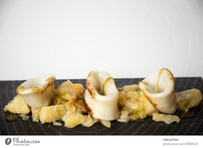 Spanisches Tintenfisch-Top mit Kartoffeln Meeresfrüchte Mittagessen Abendessen Teller Tisch Restaurant Holz frisch lecker rot Tradition Amuse-Gueule Hintergrund